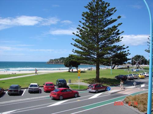 a parking lot with cars parked on a street near the beach at Pavilion Beachfront Apartments in Mount Maunganui
