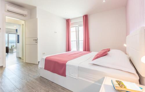 een witte slaapkamer met een bed en een raam bij Amazing Apartment In Medici With Kitchen in Kutleša