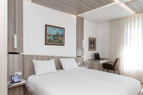 Habitación de hotel con cama grande y escritorio. en Star Hill Hotel, en Pristina
