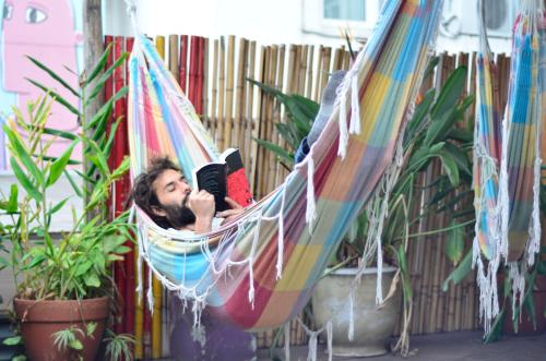 a man is laying in a hammock at Art Factory San Telmo in Buenos Aires
