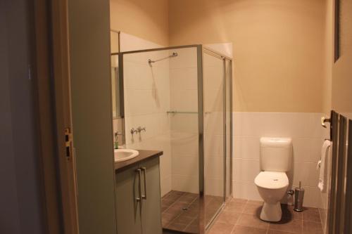 a bathroom with a shower and a toilet and a sink at Seymours On Lydiard in Ballarat