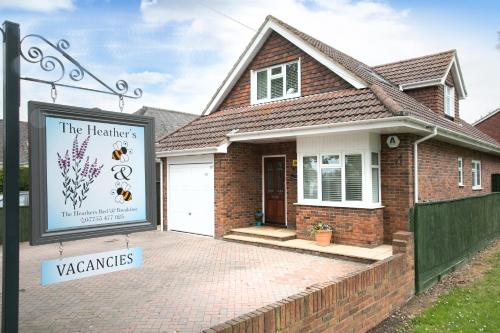 a house with a sign in front of it at The Heather's Bed and Breakfast in Christchurch