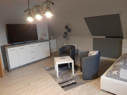 a living room with a tv and a couch and a table at Urlaub am Peenestrom in Neukalen