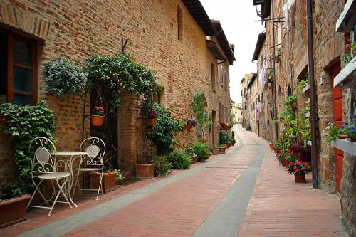 an alley with a table and chairs on a street at Villa Paradiso in Mensano