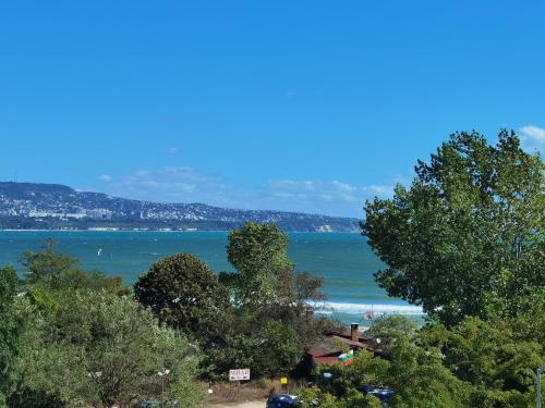 a view of the ocean from a hill with trees at By the Waves luxury beach apartment in Varna City