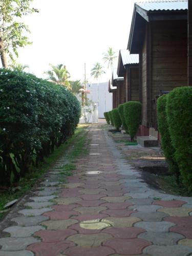a cobblestone street with bushes on the side of a house at Santonio Resorts in Anjuna