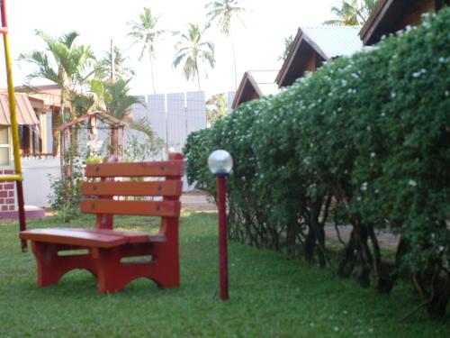 a red bench sitting in the grass next to a lamp at Santonio Resorts in Anjuna