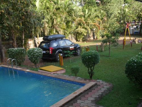 a black car parked next to a swimming pool at Santonio Resorts in Anjuna