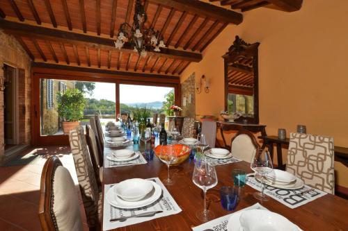 a dining room with a wooden table with chairs and a tableablish at Villa Paradiso in Mensano