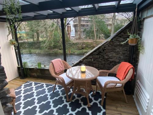 a table with chairs and a table with a umbrella at Bridge House Hotel & Silver Howe View Cottage in Grasmere