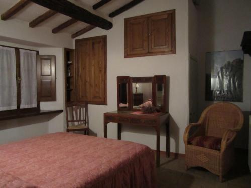 ein Schlafzimmer mit einem Bett, einem Spiegel und einem Stuhl in der Unterkunft Casette degli Avi in Rocchette di Fazio