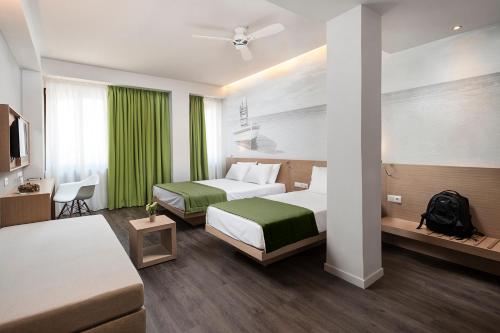 a hotel room with two beds and a tv at Kriti Hotel in Chania Town