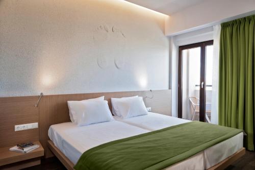 a bedroom with a large bed with a green curtain at Kriti Hotel in Chania Town