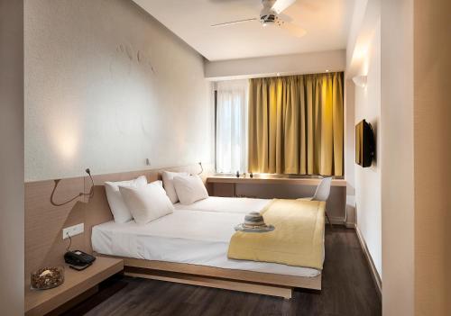 a bedroom with a white bed and a window at Kriti Hotel in Chania Town