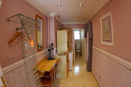 a hallway with a table and a refrigerator in a room at Rooms Beros in Maribor