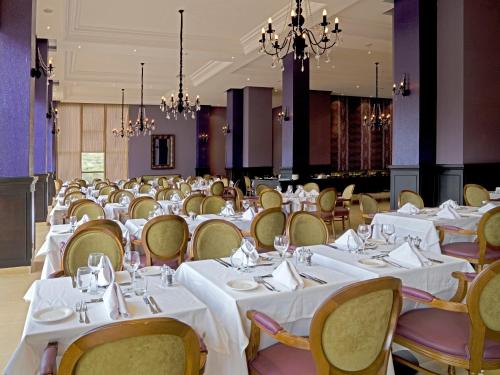 a banquet hall with white tables and chairs at Palais Medina Riad Resort in Fès