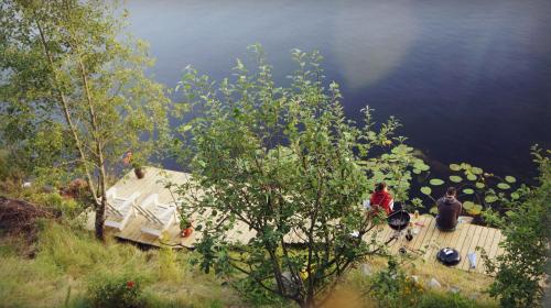 a group of people standing on a deck near a lake at Sweden Slow Living in Gösunda