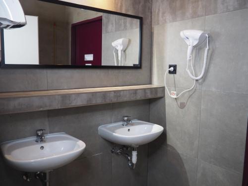 a bathroom with two sinks and a mirror at New World St Hostel and Private Room in Warsaw