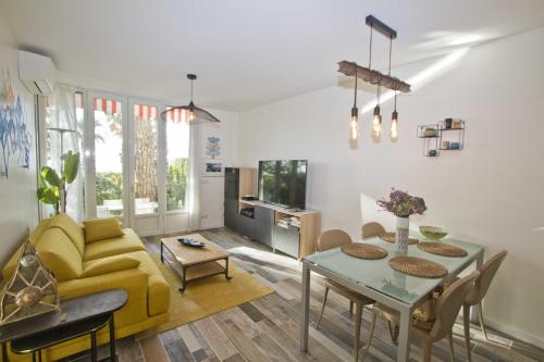 a living room with a yellow couch and a table at Garden Atlantide Promenade in Nice