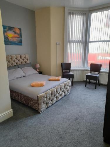 a bedroom with a large bed and two chairs at NIRO's Hotel in Blackpool