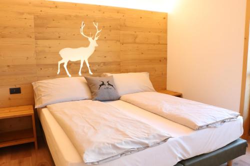 a bedroom with a bed with a deer head on the wall at Appartamenti Forhotel in Livigno