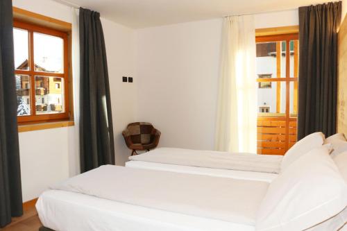 a bedroom with two beds and a window at Appartamenti Forhotel in Livigno