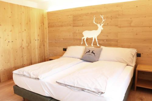 a bedroom with a bed with a deer statue on it at Appartamenti Forhotel in Livigno