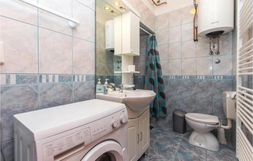 a bathroom with a washer and a toilet and a sink at Amazing Apartment In Kostrena With Wifi in Kostrena