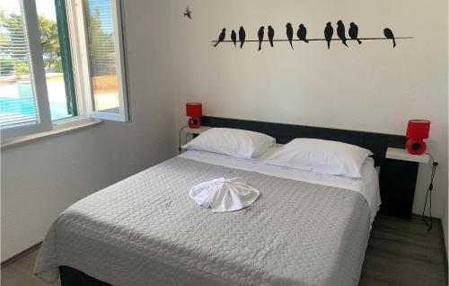 een slaapkamer met een bed met vogels aan de muur bij Amazing Home In Supetar With Private Swimming Pool, Can Be Inside Or Outside in Supetar