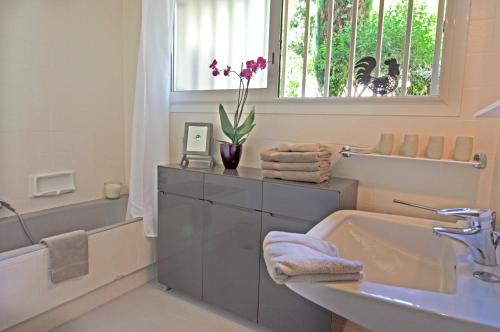 a bathroom with a sink and a tub and a window at 90m2 Apartement - Les Palmiers de Cannes in Cannes