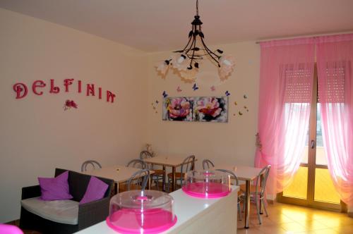 uma sala de jantar com mesas e cadeiras cor-de-rosa em B&B Delfinia em Carovigno
