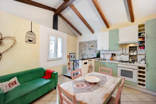 a living room with a green couch and a table at La casa nel Caruggio in Diano Arentino