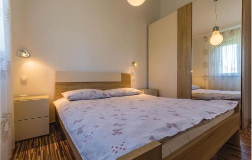 a bedroom with a large bed and a mirror at 3 Bedroom Awesome Home In Fazana in Fažana