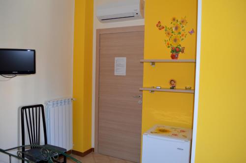 um quarto com uma porta e uma parede amarela em B&B Delfinia em Carovigno