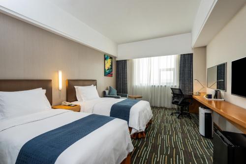 En eller flere senger på et rom på Holiday Inn Express Shanghai New Jinqiao, an IHG Hotel