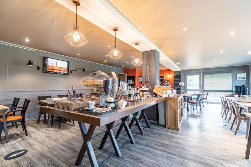 a restaurant with tables and chairs in a room at KYRIAD ROUEN NORD - Mont Saint Aignan in Mont-Saint-Aignan