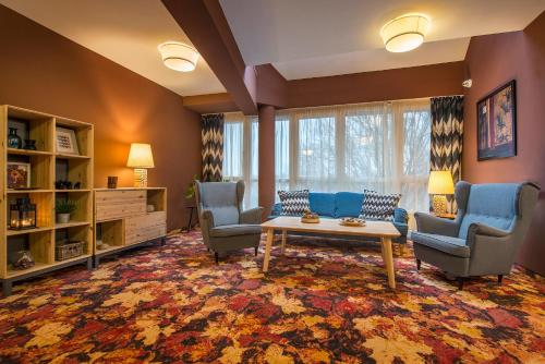 a living room with chairs and a table and a couch at Hotel Lajta Park in Mosonmagyaróvár