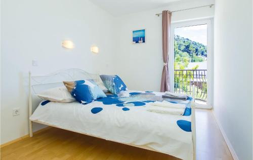 ein Schlafzimmer mit einem Bett mit blauen Kissen und einem Fenster in der Unterkunft Beautiful Home In Pisak With Wifi in Pisak