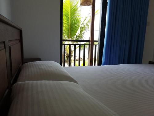 a bedroom with a bed and a window with a view at Horizon Palace - Kabalana in Ahangama