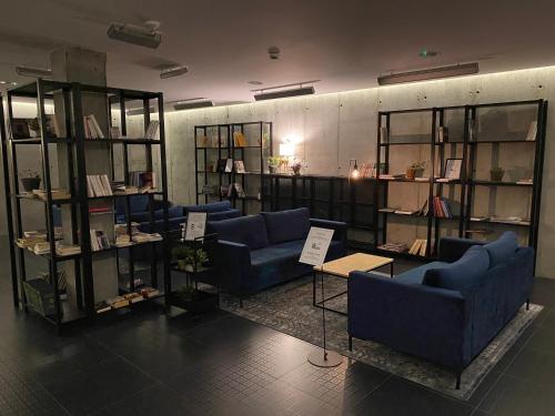 Pokój z niebieskimi kanapami i półkami z książkami w obiekcie Green Loft Gdynia w mieście Gdynia