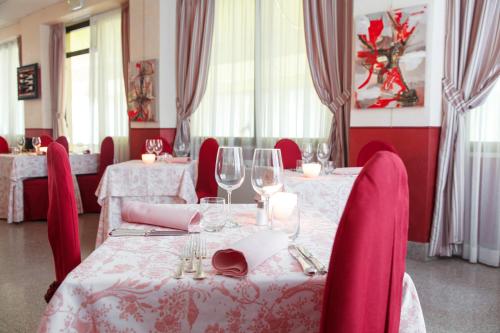 a dining room with tables and chairs with wine glasses at Allegroitalia Alassio Rosa in Alassio