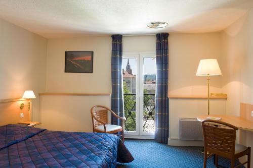 Cette chambre comprend un lit, un bureau et une fenêtre. dans l'établissement Hotel Le Bourbon Pau Centre, à Pau