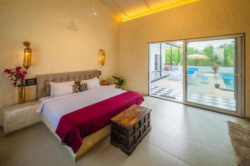 a bedroom with a large bed and a sliding glass door at SaffronStays Turquoise Maison, Karjat in Karjat