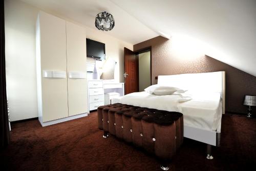 a hotel room with a bed and a clock on the wall at Pensiunea Ellemar in Vatra Dornei