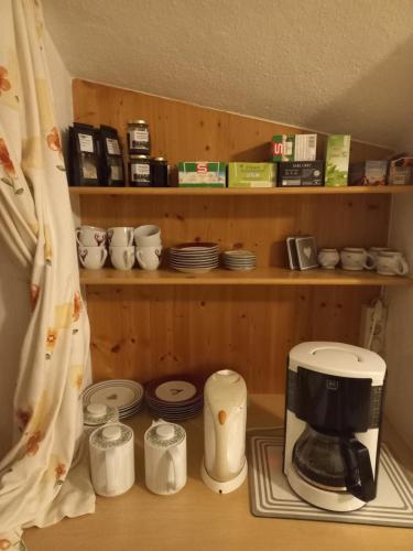 a kitchen with a coffee maker and cups and plates at Gästeheim Auwitsch in Mayrhofen