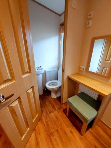 - une petite salle de bains avec des toilettes et une porte dans l'établissement Mobilhomes du Kerdidrouz du Léon PONT AVEN, à Pont-Aven