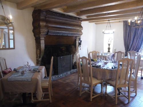 a dining room with a table and a fireplace at Le Chapeau Rouge in Lusignan