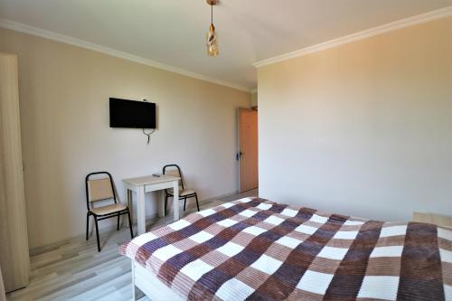 Un dormitorio con una cama, una mesa y un televisor. en Villa Gio, en Mtskheta