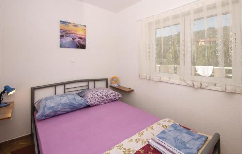 ein kleines Schlafzimmer mit einem Bett und einem Fenster in der Unterkunft Beautiful Apartment In Poljica With Wifi in Poljica