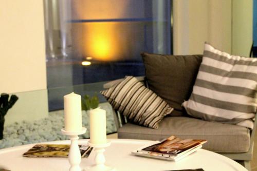 a living room with a couch and candles on a table at Giardino Dei Pini - Boutique Hotel in Alliste